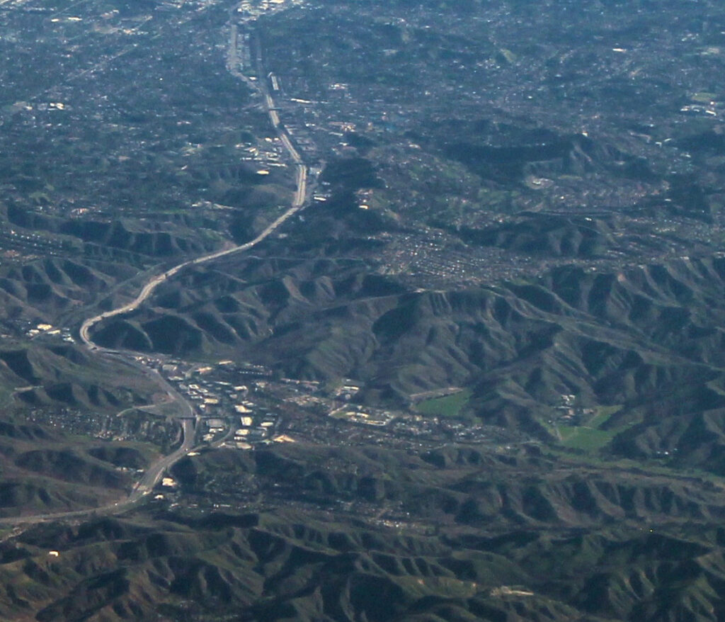 Aerial view over Calabasas toward the San Fernando Valley, with the 101 corridor and surrounding hills