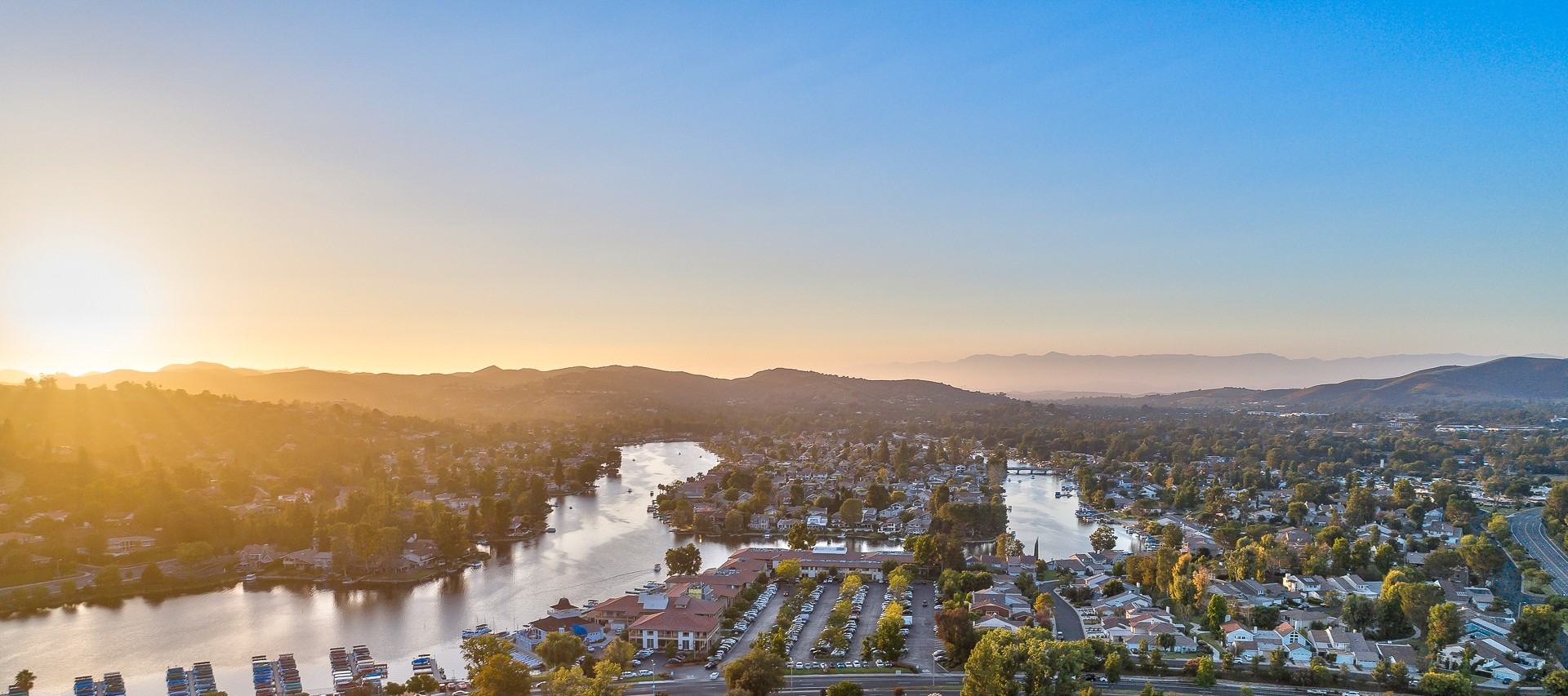 Aerial view of Westlake Lake at sunset in Westlake Village, CA, with lakefront homes, the lake and the Santa Monica Mountains